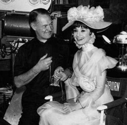Audrey Hepburn as Eliza Doolittle on the set of the movie “My Fair Lady” with cinematographer Harry Stradling, Sr. (c. 1964)