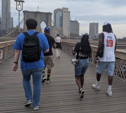Knicks piligrams including No. 19 Willis Reed walk in over Brooklyn Bridge.