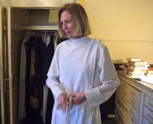 The Rev.Katharine Flexer adjusts her robes before Sunday service at St. Michael's Church. Photo by William Mathis.