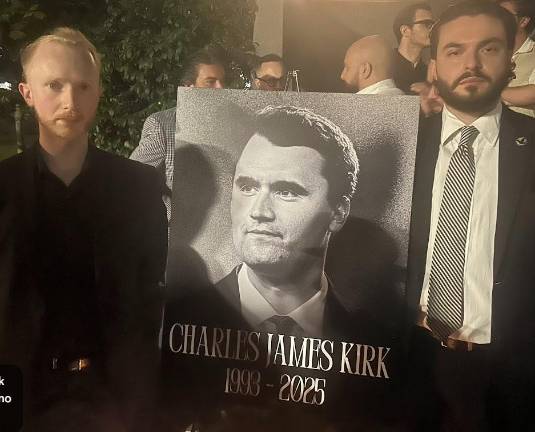 The president and vice president of the Young Republicans stand beside a picture of Charlie Kirk, the conservative podcaster who was killed by an assassin in Utah. Several hundred mourners turned up at the hastily called memorial in Madison Square Park.