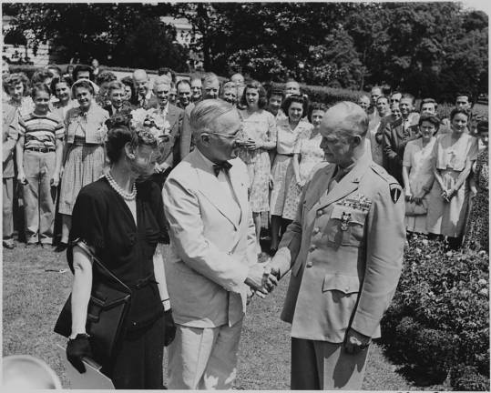 President Harry Truman shakes hands with General Dwight D. Eisenhower after awarding him the distinguished service award in 1945 while wife Mammie looks on. Photo: Abbie Rowe, National Archives and Records Administration, Harry S. Truman Presidential Library.
