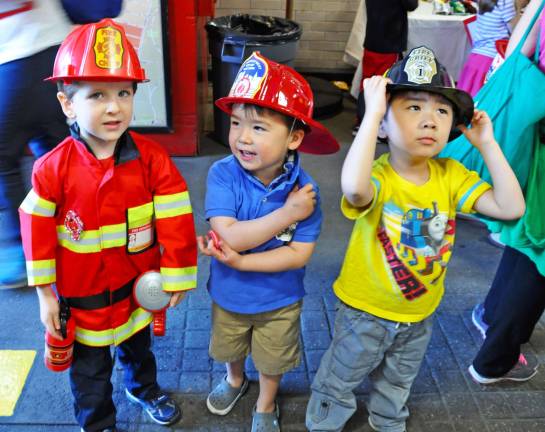 From left, Thomas Rowe, Lincoln Rowe, and Milo Hu proudly wear their Engine 74 firehouse hats during the open house. Photo by Veronica Bruno