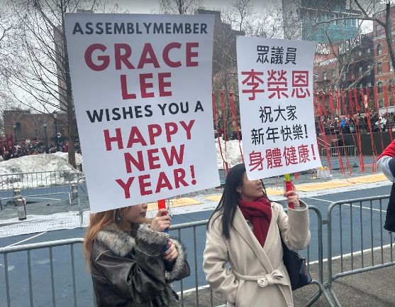 Assembly member Grace Lee, who is seeking a NYS Senate seat being vacated by Brian Kavanagh, displays New Year’s greetings in English while a staffer displays the greeting in Mandarin Chinese.