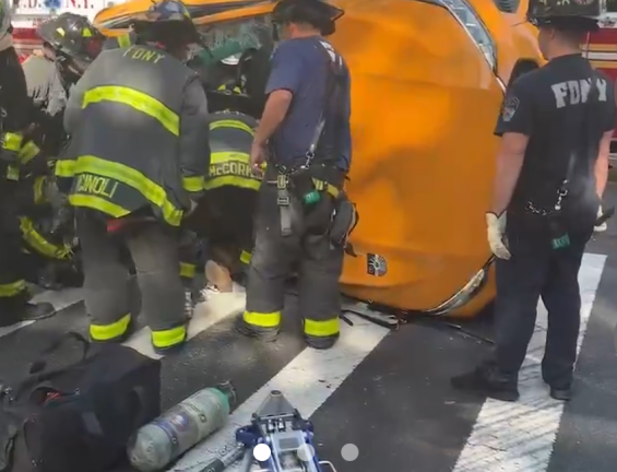 Firefighters removing a man from an overturned taxi on W. 77th and Broadway, at around noon on October 22.