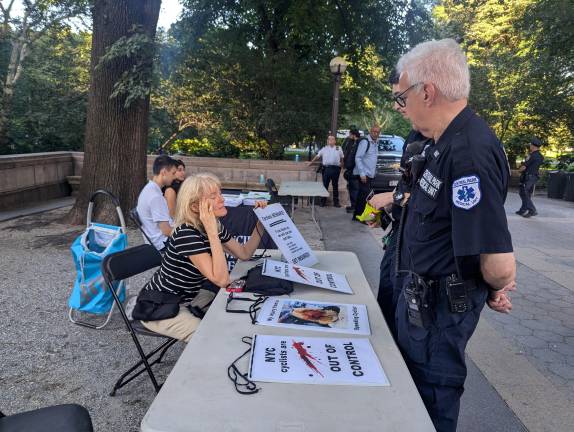 Julie Harvey (seated), who said she was injured in a collision by a speeding biker in Central Park, speaks to Central Park Medical Unit about bicycle concerns.