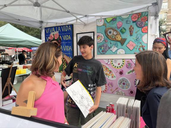 Gov. Hochul visits with the Katz family as Jacob Katz shows off his live drawing of the day.