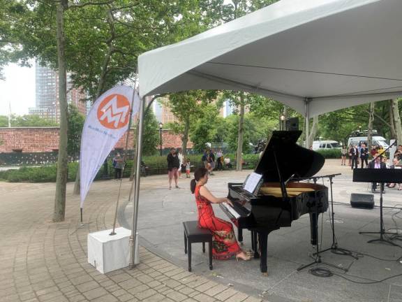 Mina Kim, conductor of the Purchase Symphony Orchestra, was one of two pianists for the starting event of the day at Battery Park. Photo: Ralph Spielman