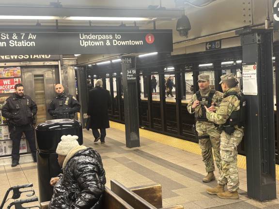 Two NYPD officers and two members of the National Guard at the 34th St/Penn Station subway station. Gov. Hochul proposed funding the copss/National Guard surge at least six more months. Subway crime began to dip after the first surge delivered a year ago in Feb. 2025.