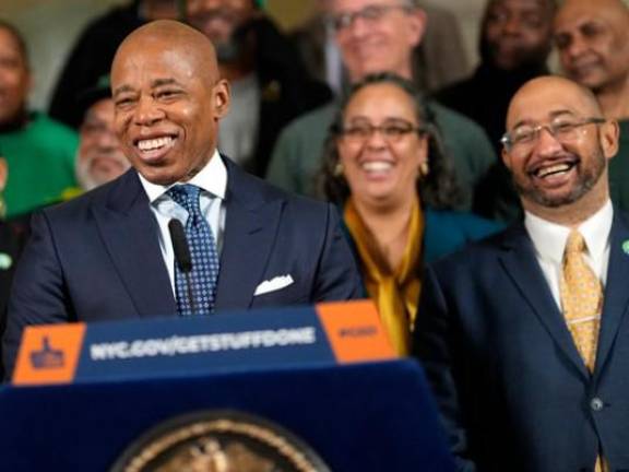 <b>In happier times, Eric Adams (at mic) was joined by DC37 executive director Henry Garrido (far right) in mid Feb. 2023 when he announced a new labor pact with the nearly 90,000 employee union, the largest in the city’s workforce.</b> Photo: Ed Reed/Mayoral Photography Office