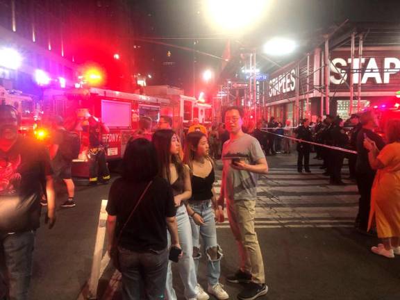 <b>Traffic was snarled and spectators gathered on West. 35th St. on April 14 as firefighters extinguised a blaze in an unoccupied commercial building.</b> One firefighter was injured. Photo: Keith J. Kelly