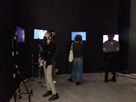 Viewers listen to the children’s stories at the YPC AloneTogether exhibit. Photo: Karen Camela Watson