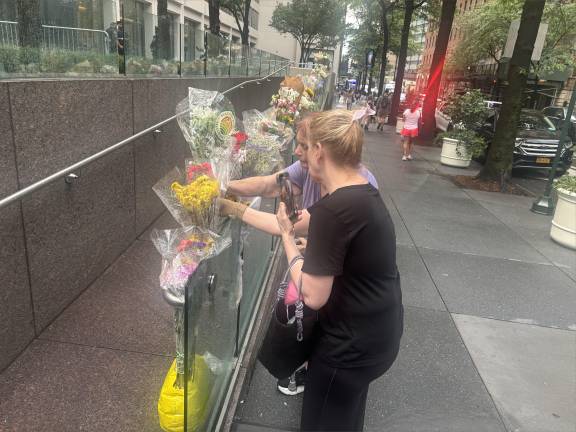 A torrential downpour on July 30 did not keep a steady stream of mourners from placing flowers at the makeshift memorial to the four victims on the shooting outside 345 Park Ave., near East 51st Street.