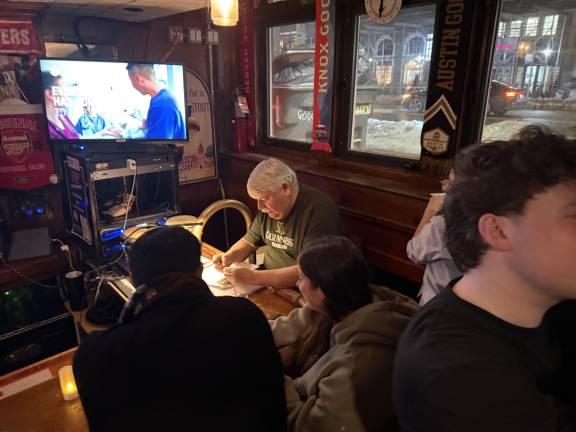 Pete Sullivan, aka Quizmaster Pete, has his game face on as he prepares questions for the O’Hanlon’s Pub Trivia he hosts weekly at the East Village pub.