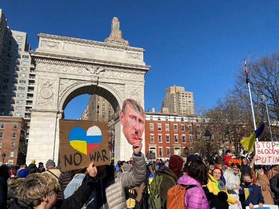 Signs: a paper cutout of Putin as Hitler; “No War” and “Stop Bloody Putin.”