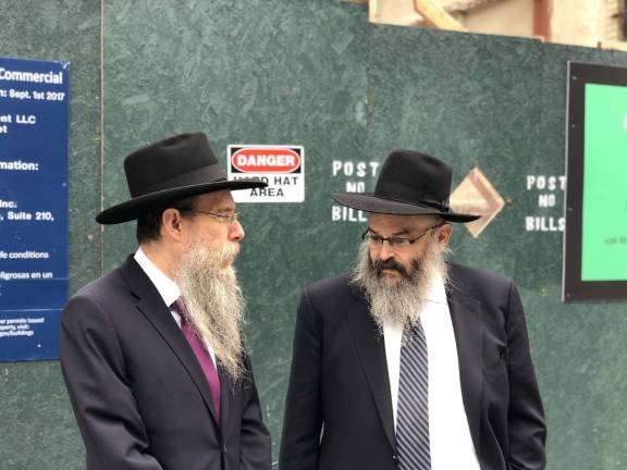 Rabbi Meir Ossey, at left, associate director of the Chabad of the West Side, and Rabbi Shlomo Kugel, the group&#x2019;s director and co-founder, stand before a construction fence on West 96th Street where Chabad is developing its new home.&#xa0;Photo: Chabad of the West Side&#xa0;