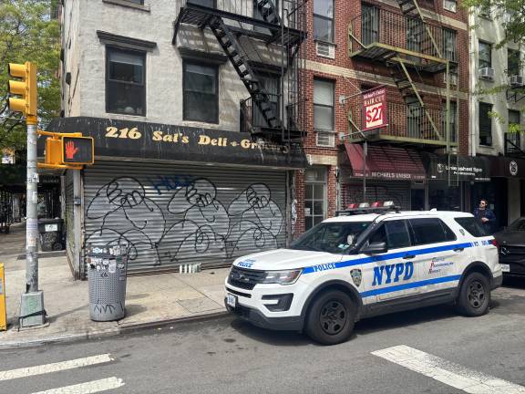 A police cruiser from the 9th Pct sits outside Sal’s Deli where 28-year-old Abdul Saleh worked. He was killed after a scuffle with an unidentified man.