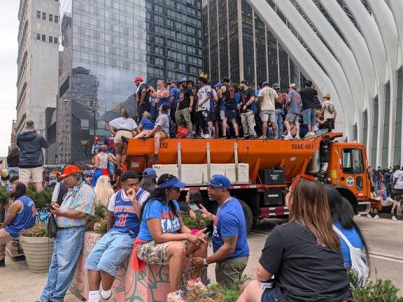 Knicks parade fans take over a sanitation truck outside the Oculus.