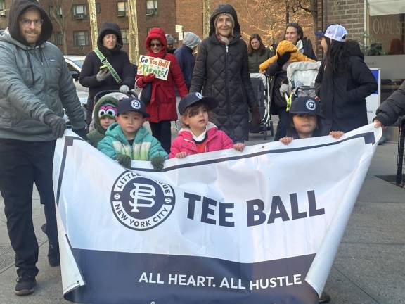 Frozen tee ballers gamely hold their division sign during the opening day parade of the Peter Stuyvesant LIttle League on March 28.