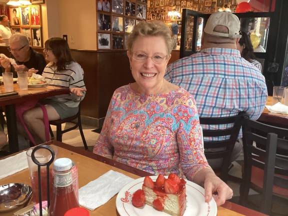 Visitor Barbara, visiting with her husband on a two day visit from Connecticut displays her slice of strawberry shortcake, which is $16 a slice. After the taking of a small bite of one later, one could say it is just simply Deli Nirvana.