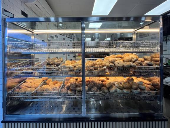 Some of the 14 varieties of bagels are on display for all to see in this new display case, which provides a peek back into the baking area; in the previous store on premises, there was a big wall that prevented that.