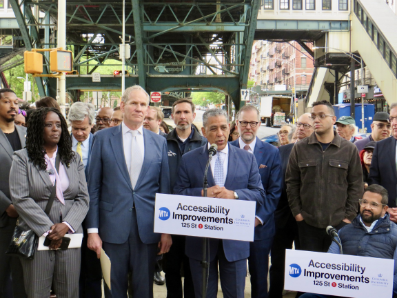 Congress man Adriano Espaillat speaks at the May 8 press conference with MTA chairman Janno Leiber (left of speaker) and Comptroller Mark Levine (right rear of speaker).