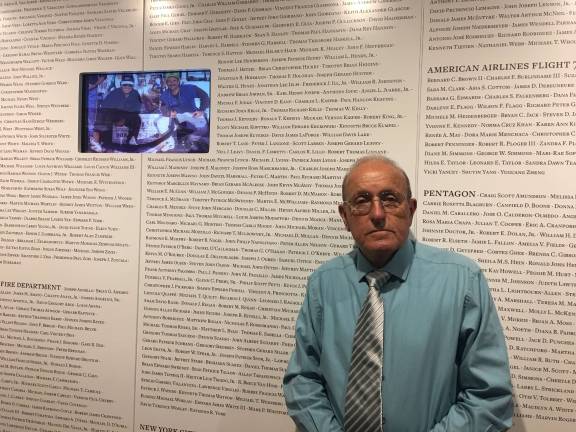 Lee Ielpi, a retired firefighter and co-founder of the 9/11 Tribute Center, stands in front of a wall listing the name every victim, including his son Jonathan. The center reopened in a new location on June 7. Photo: Madeleine Thompson