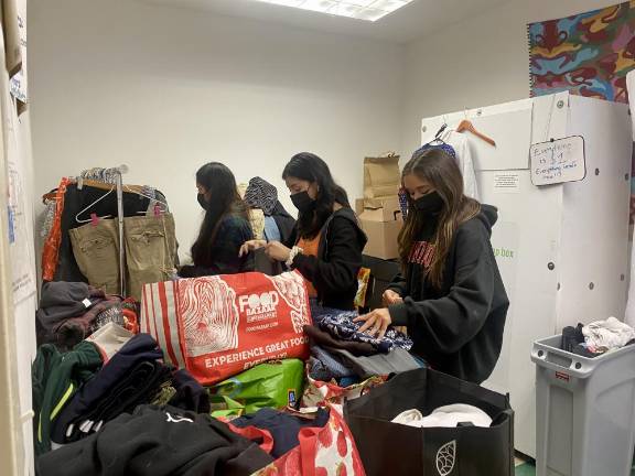 Arielle (right) and other volunteers sorting through donation. Photo: Ava Manson