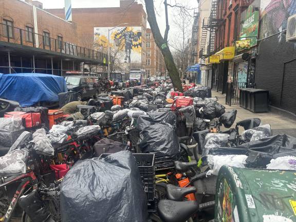 Trash Pileup on Eleventh Street just off of First Ave. E-bikes and heavy scooters are on the sidewalk and in the street.