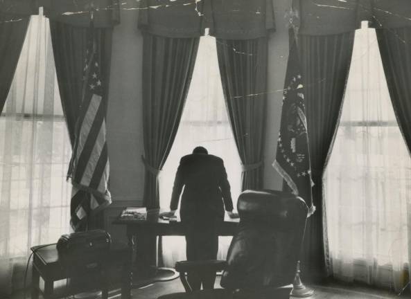 A black and white photo of President John F. Kennedy in the Oval Office in 1961 entitled, “The Lonliest Job” is among the many riveting tabloid photographs on display at the Howard Greenberg Gallery through November 16.