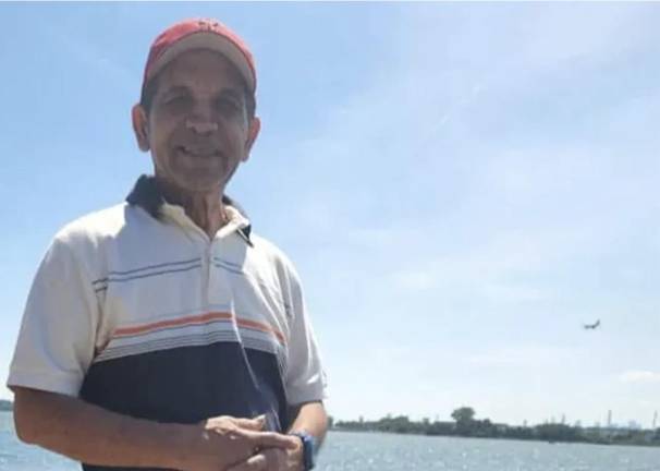 Morton Williams stock clerk Leobardo Hernandez in happier times on Jamaica Bay, a plane landing at JFK airport behind him.