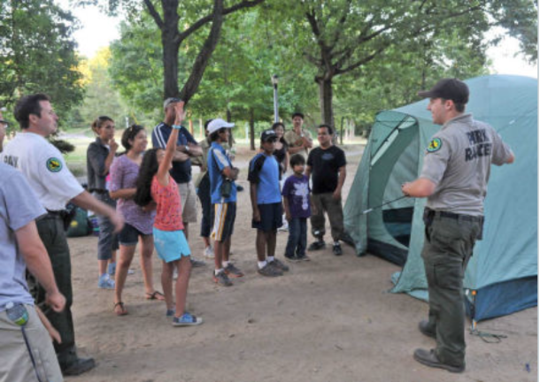 Urban Park Rangers hosting Family Camping and helping families set up tents.