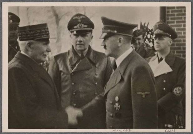 The infamous 1940 photo of Marshal Philippe Petain, the French hero of the Battle of Verdun in World War I who became the leader of the collaborationist Vichy France government following the German invasion of World War II, shown shaking hands with Adolf Hitler. Mayor Bill de Blasio has suggested removing a marker on lower Broadway that commemorates the ticker tape parade that was held in 1931 to honor Petain. Photo: New York Public Library collection