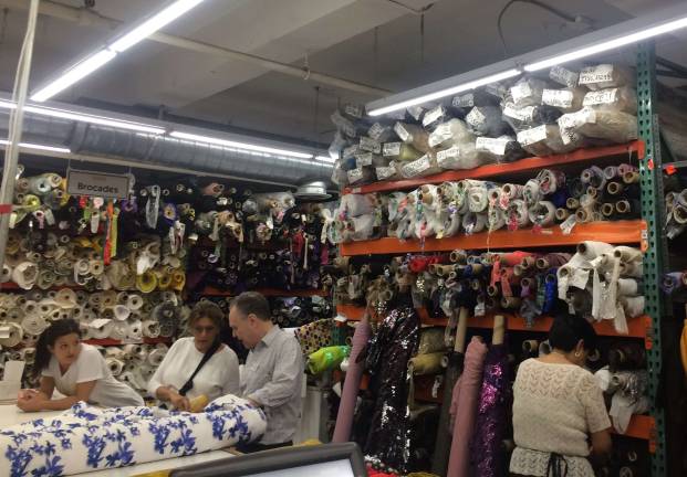 Employees at Mood Fabrics cut swatches of fabric for designers. Photo: Lily Haight