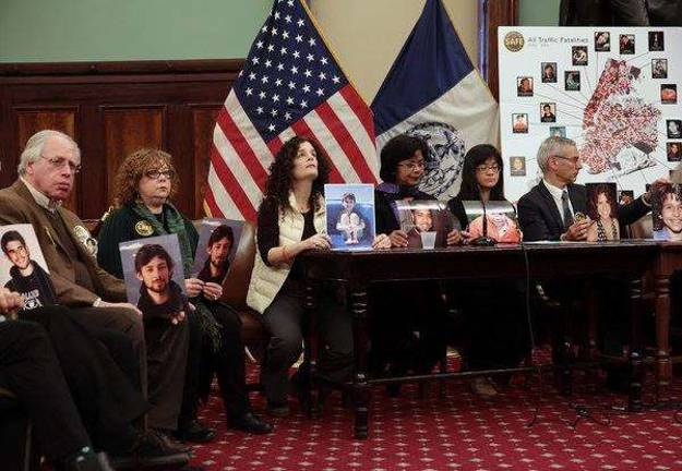 Dana Lerner, seated at left holding a photo of her son, at a press conference of families who have lost loved ones in pedestrian accidents.