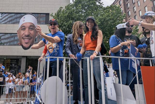 Knicks parade guest Ben Stiller hold a giant Josh Hart head, Julie Menin standing beside them.