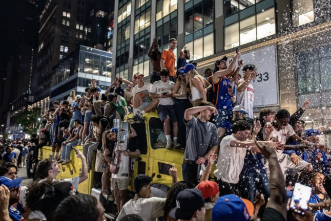Knicks fans cheering on top of a truck.