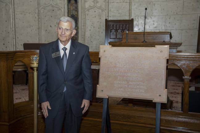 Charlie Salomon, president of Riverside Memorial Chapel, stands with a plaque commemorating the chapel’s founders, the Rosenthal Family.