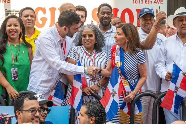 Zohran Mamdani shakes hands with Governor Hochul, flanked by fellow State Assembly Members Amanda Septimo (left) and Karines Reyes. That’s Mayor Adams in the baseball cap and US Representative Adriano Espaillat (far right) in a white straw fedora.