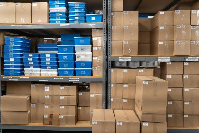 Several large and small cardboard boxes that contain cacao are neatly arranged throughout the factory.