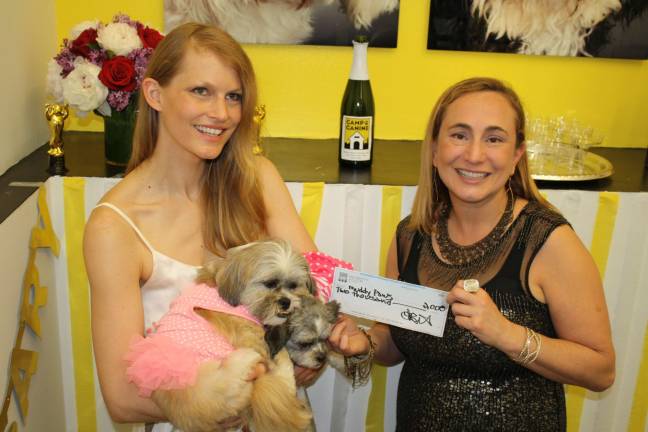 Camp Canine founder Tania Isenstein, right, and longtime Muddy Paws Rescue volunteer Hartje Andresen&#xa0;pose with a $2,000 check to benefit Muddy Paws. Photo: Razi Syed