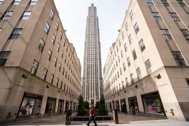 A commuter sporting latex gloves passes by Rockefeller Center, March 18, 2020.