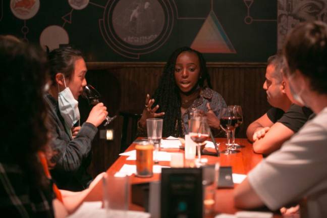 A group of guests sipping wine and sharing their experiences. Photo: Karen May