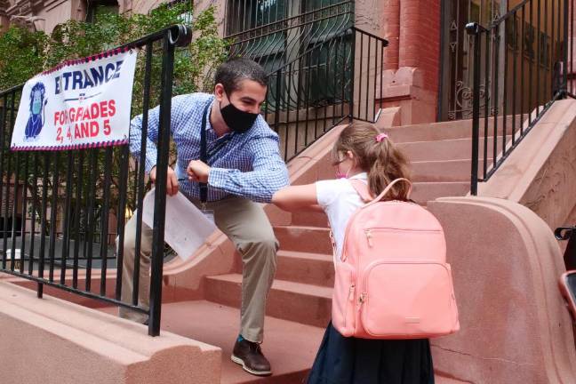 Teacher greets a student on the first day of school, 2020. Photo courtesy of Dwight School