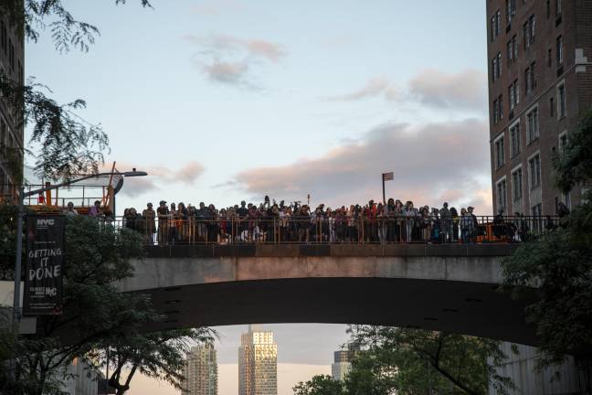 Crowd of people gathered at Tudor City Bridge. From street angle on 42nd Street between First and Second Avenues.