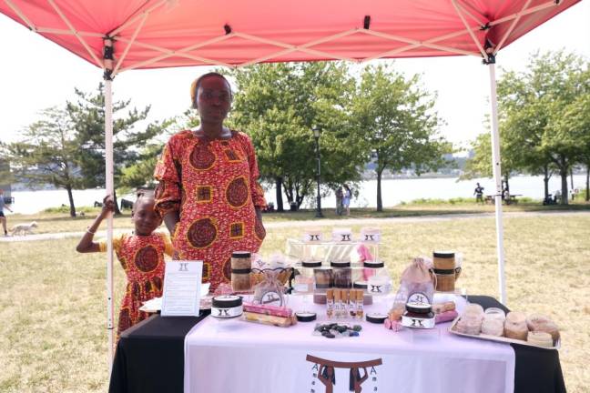 Nana Boateng at a tent for Juneteenth at As Black As It Gets! with her 6-year-old daughter wearing dresses from Ghana. They are in front of Boateng’s 100% vegan skincare and hair product line called Odehyee LLC. Photo: Beau Matic