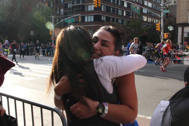 New York City Marathon runner Amy Remick, 38, hugs friend Carrie Stock, 37, at the race's 17-mile mark and just outside Mile 17, a First Avenue bar, Sunday. Photo: Nomin Ujiyediin