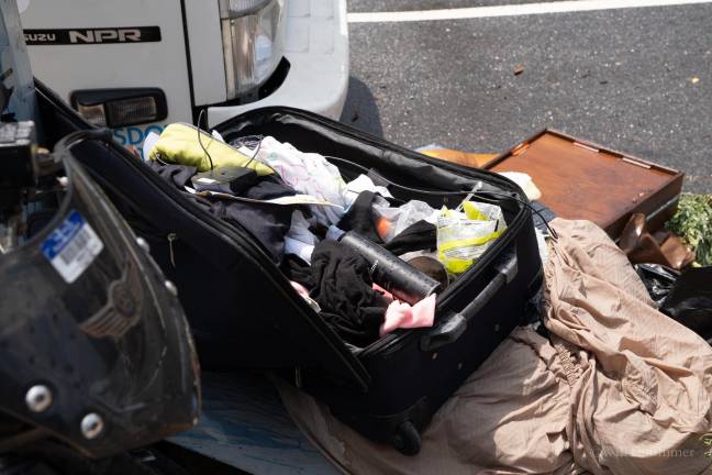 Trash and stolen goods line the streets near the structures in suitcases.