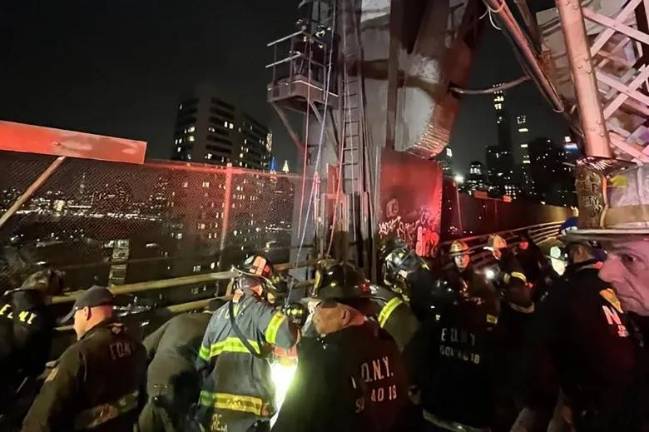 Firefighters work to rescue a teen boy who fell down a 50 ft worker’s maintenance shaft on the Queensboro Bridge on Feb. 16. Some social media posters said the boy had been lying at the bottom of the shaft for hours before 911 was called. The report is unconfirmed, but the NYPD was not releasing further details.
