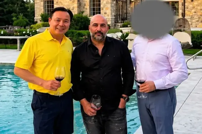 A photograph included in federal court filings shows Frank Carone (center) with Yan Po Zhu (left), owner of the Long Island City Microtel Inn at the center of the alleged bribery scheme. Zhu and Carone have both pleaded not guilty.