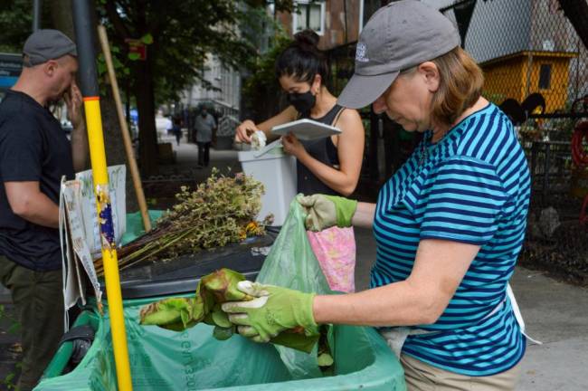 Gwen Ossenfort (right) sorting through compost drop-off contributions. Photo: Abigail Gruskin